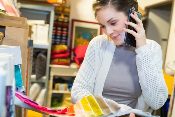 Žena Telefonu Při Pohledu Tkaniny Vzorkovač — Stock fotografie