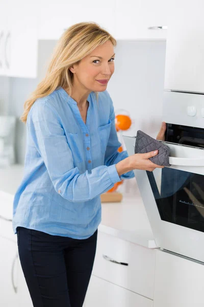Pretty Blonde Opening Oven Home Kitchen — Stock Photo, Image
