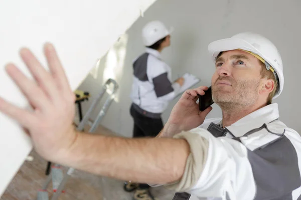 男性建設労働者が携帯電話で — ストック写真