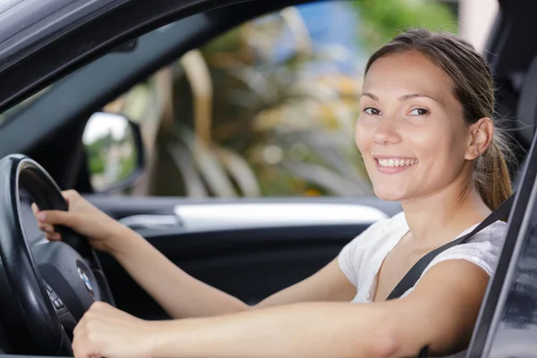 若い女性ドライバーがカメラに笑顔で — ストック写真
