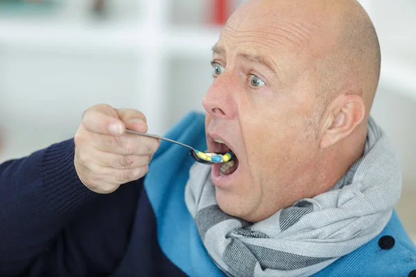 錠剤のスプーンを食べる男 — ストック写真