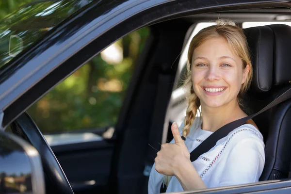 車から親指を出す女性は — ストック写真