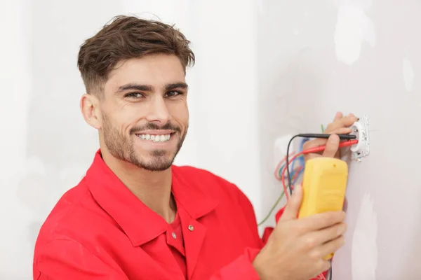 Happy Electrician Installs Socket — Stock Photo, Image