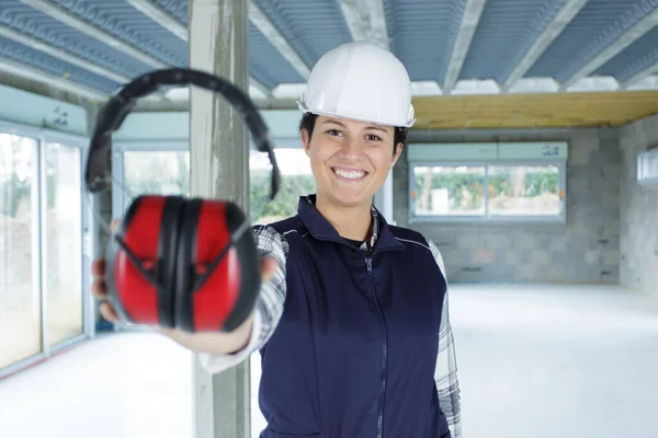 woman contractor offering noise cancelling headphones