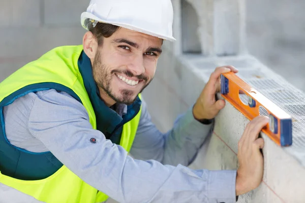 Constructor Masculino Feliz Usando Nivel —  Fotos de Stock