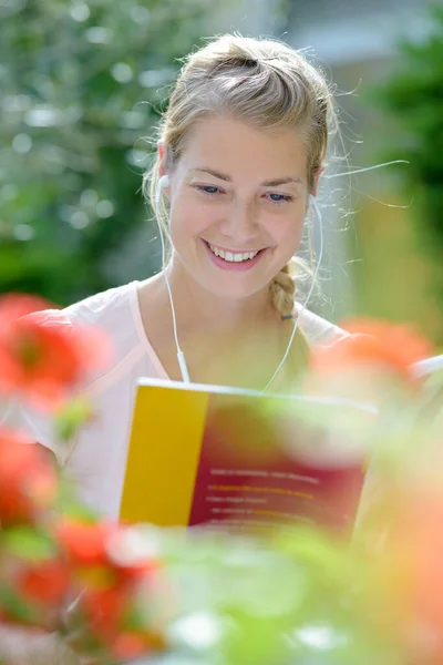 Frau Liest Draußen Während Sie Musik Hört — Stockfoto