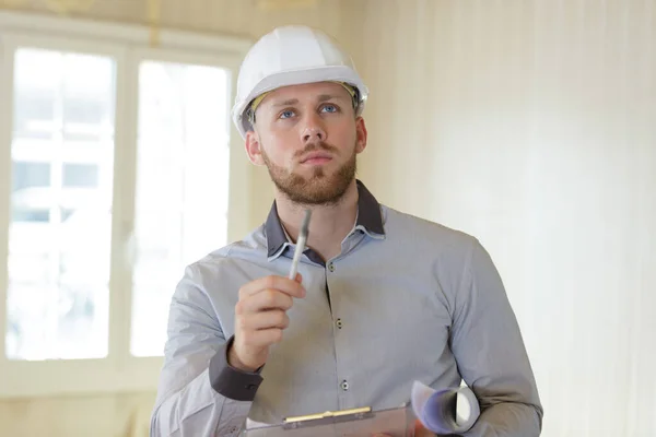 Concentré Jeune Homme Dans Construction Casque Écriture Sur Presse Papiers — Photo