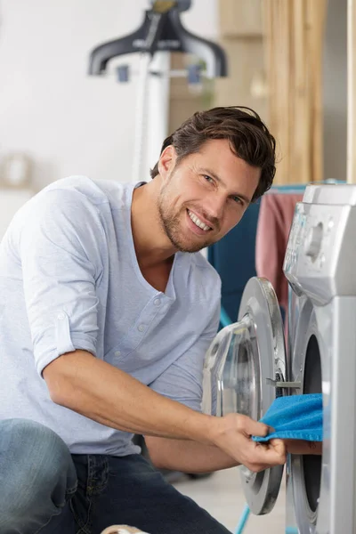 Adam Çamaşır Makinesine Renkli Giysiler Koyuyor — Stok fotoğraf