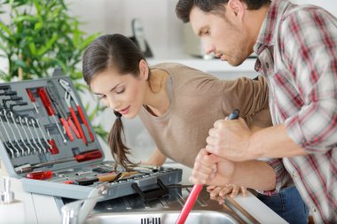 couple dealing with a blocked sink with a plunger clipart