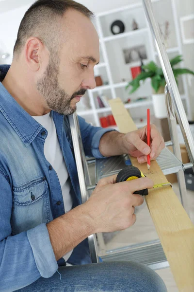 Man Meet Een Stuk Hout Thuis — Stockfoto