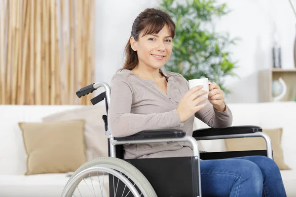 車椅子の障害者が自宅でコーヒーを飲み — ストック写真