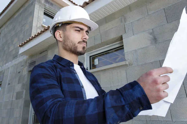 engineer man looking at plan on construction site