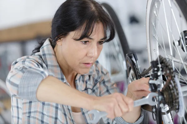 Reife Mechanikerin Repariert Fahrrad — Stockfoto