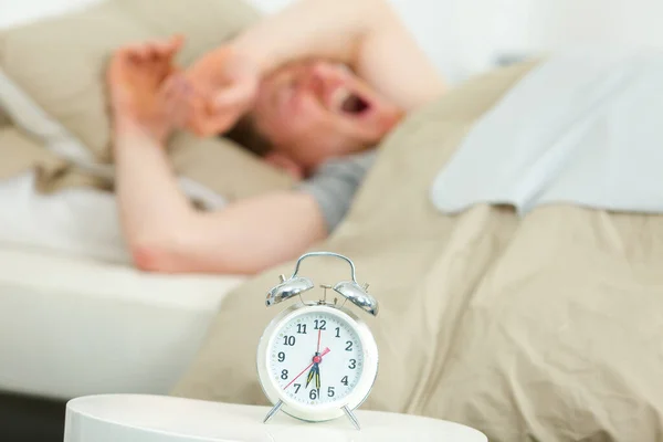 Young Man Lying Bed Yawning Alarm Clock — Stock Photo, Image