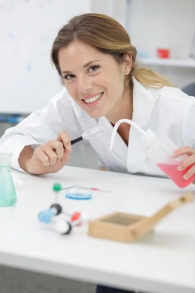 Vrouw Glimlachen Terwijl Kijken Naar Een Reageerbuis — Stockfoto