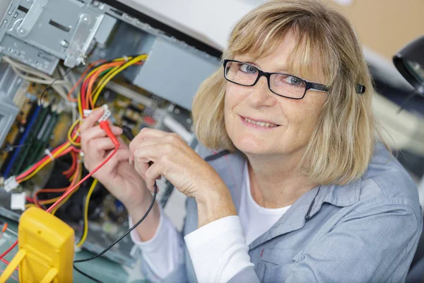 電圧測定中の成熟した女性技術者 — ストック写真