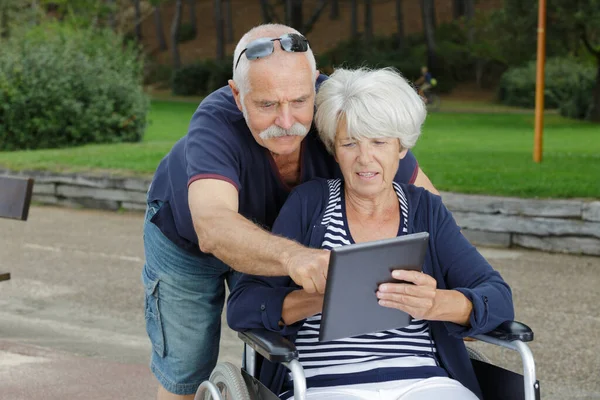 Pareja Ancianos Aire Libre Mujer Silla Ruedas Mirando Tableta — Foto de Stock