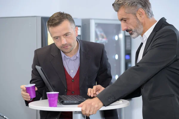手握咖啡的商人与笔记本电脑一起工作 — 图库照片