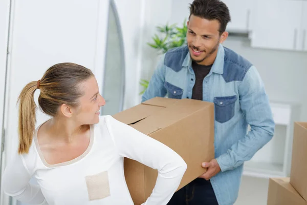 Casal Carregando Uma Caixa Dentro Casa Durante Movimento — Fotografia de Stock