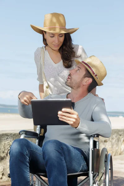 障害者の男性とデジタルタブレットを持つ彼のガールフレンド — ストック写真