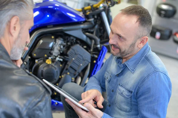 Mannen Zoek Naar Tablet Naast Motor — Stockfoto