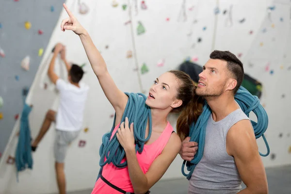 woman pointing up at indoor climbing wall