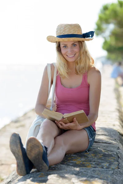 一个女人在海边看书的肖像 — 图库照片
