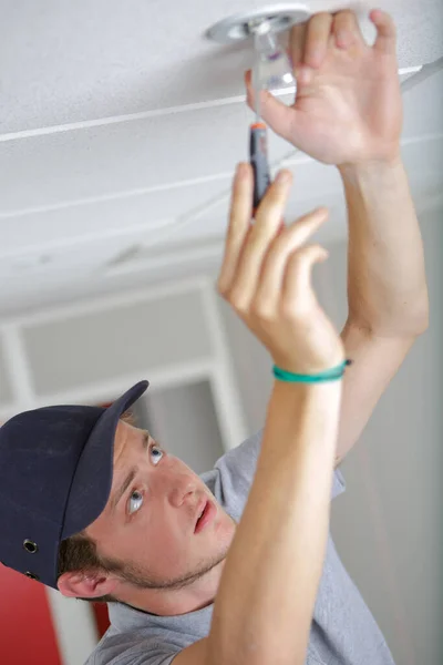 Jeune Homme Fixant Ampoule Sous Les Projecteurs — Photo