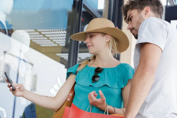 Coppia Che Utilizza Smartphone Fuori Una Boutique — Foto Stock