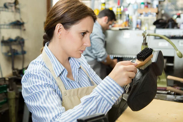 Arbeiterin Bürstet Schuhe Für Kunden — Stockfoto