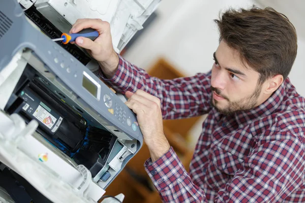 若い男性技術者がデジタルコピー機を修理し — ストック写真