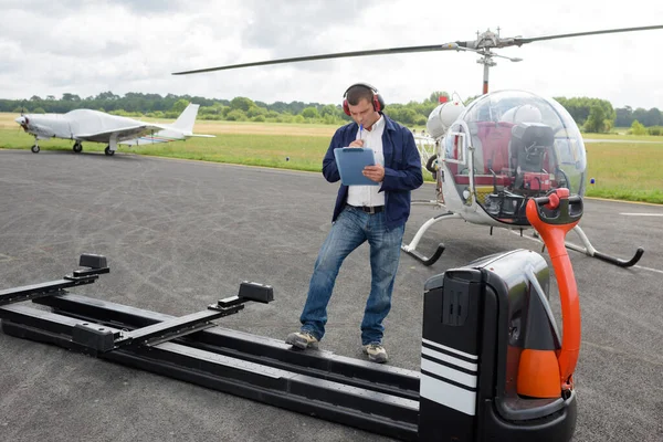 Pracownik Podkładką Pisania Obok Przyczepy Helikoptera — Zdjęcie stockowe