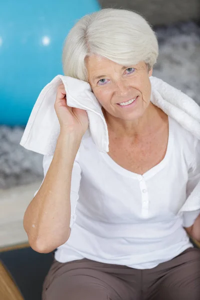 笑容满面的老妇人脖子上缠着毛巾 — 图库照片