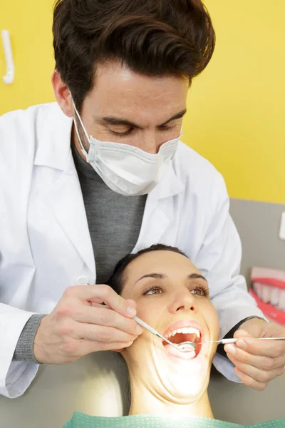 Dentista Masculino Revisando Paciente Femenino Con Espejo —  Fotos de Stock