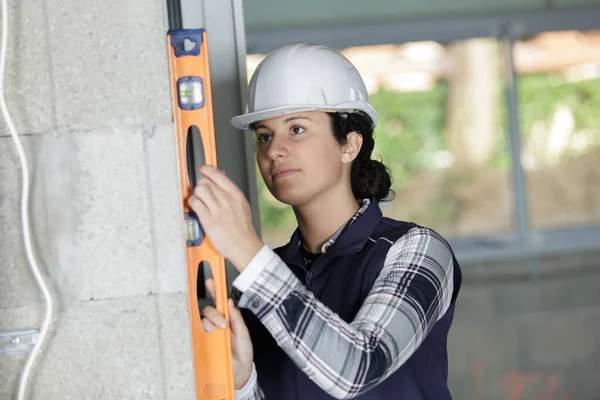 Concentrated Female Construction Worker Holding Level — Stock Photo, Image