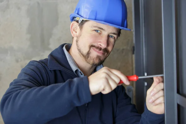 Bauarbeiter Mit Schraubenzieher Auf Metallrahmen — Stockfoto