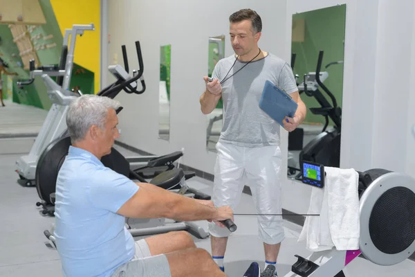 man exercising on a rowing machine at gym