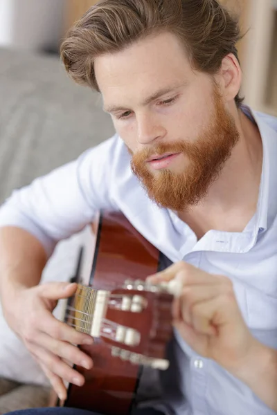 Ung Skäggig Man Som Trimmar Sin Gitarr — Stockfoto