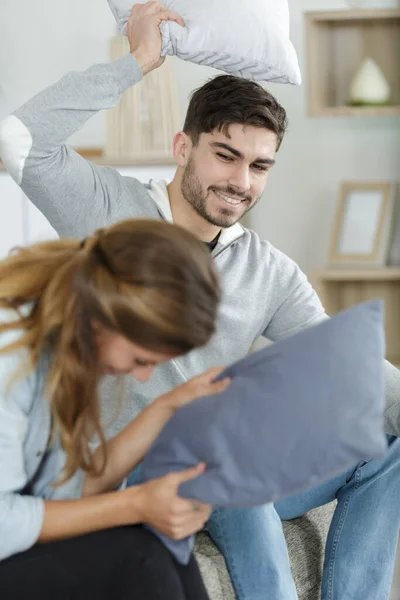 Happy Couple Jokingly Holds Pillow Fight Sofa — Stock Photo, Image