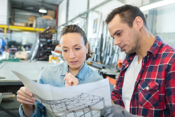 Vrouwelijke Mannelijke Werknemer Kijken Naar Plannen Magazijn — Stockfoto