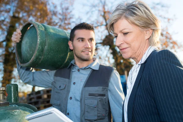 worker carrying refillable empty tank