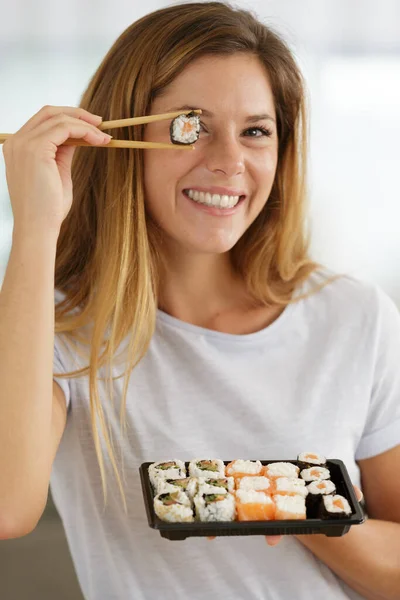 Sonriente Joven Mujer Sosteniendo Sushi Delante Los Ojos —  Fotos de Stock