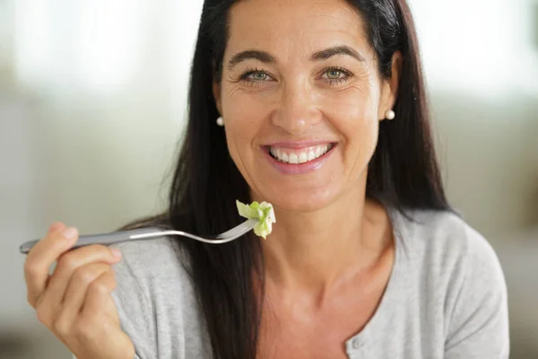Gelukkig Huisvrouw Proeven Groente Salade Glimlachen — Stockfoto