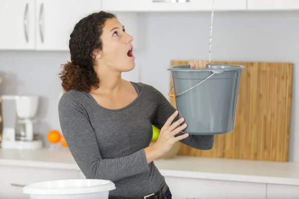 Vrouw Houden Emmer Terwijl Water Druppels Lekken Uit Het Plafond — Stockfoto