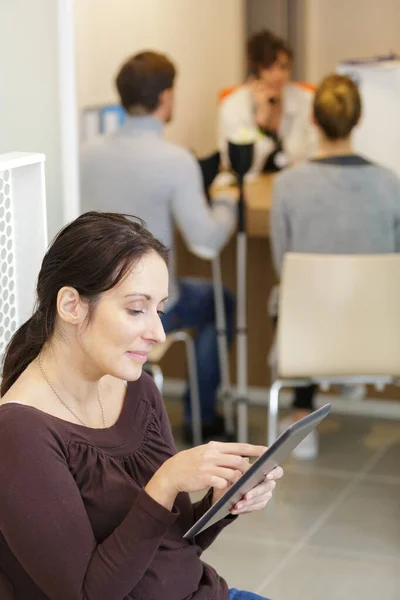 Bekleme Alanında Dijital Tablet Kullanan Konsantre Bir Kadın — Stok fotoğraf