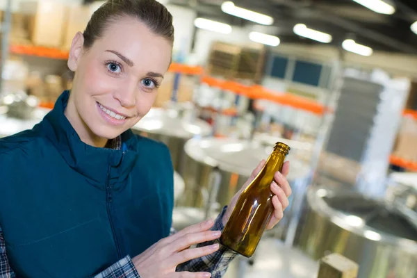 Mulher Segurando Uma Garrafa Vazia Uma Fábrica — Fotografia de Stock