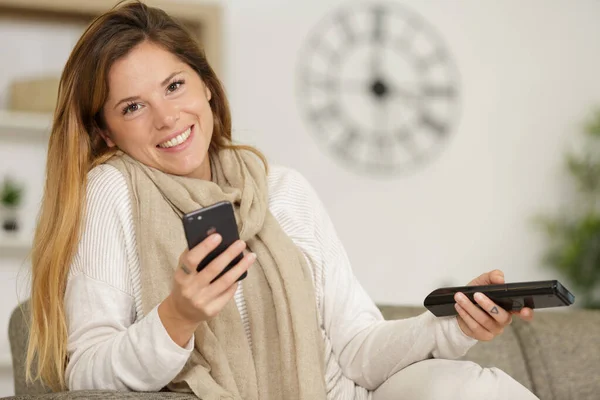 快乐的女人在沙发上用手机 — 图库照片