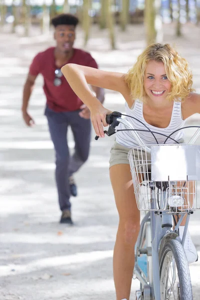 公園で自転車に乗る幸せな女性サイクリストは — ストック写真