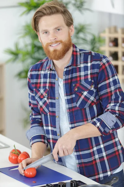幸せな男まな板にトマトを切る — ストック写真