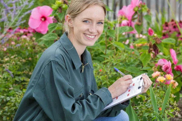 Female Florist Writing Clipboard Stock Photo